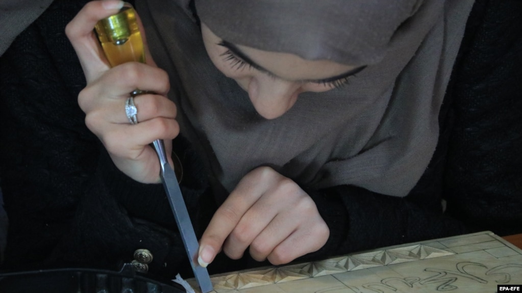 Una donna afghana si dedica alla scultura del legno Nuristani in un laboratorio a Herat il 29 novembre. Un gruppo di quattro donne si è dedicato a preservare un'antica tradizione di scultura del legno trovata in una regione montuosa e remota dell'Afghanistan orientale.