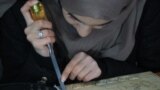 An Afghan woman engages in Nuristani wood carving at a workshop in Herat on November 29.<br />
<br />
A group of four women has dedicated themselves to preserving an ancient tradition of wood carving found in a mountainous and remote region of eastern Afghanistan.