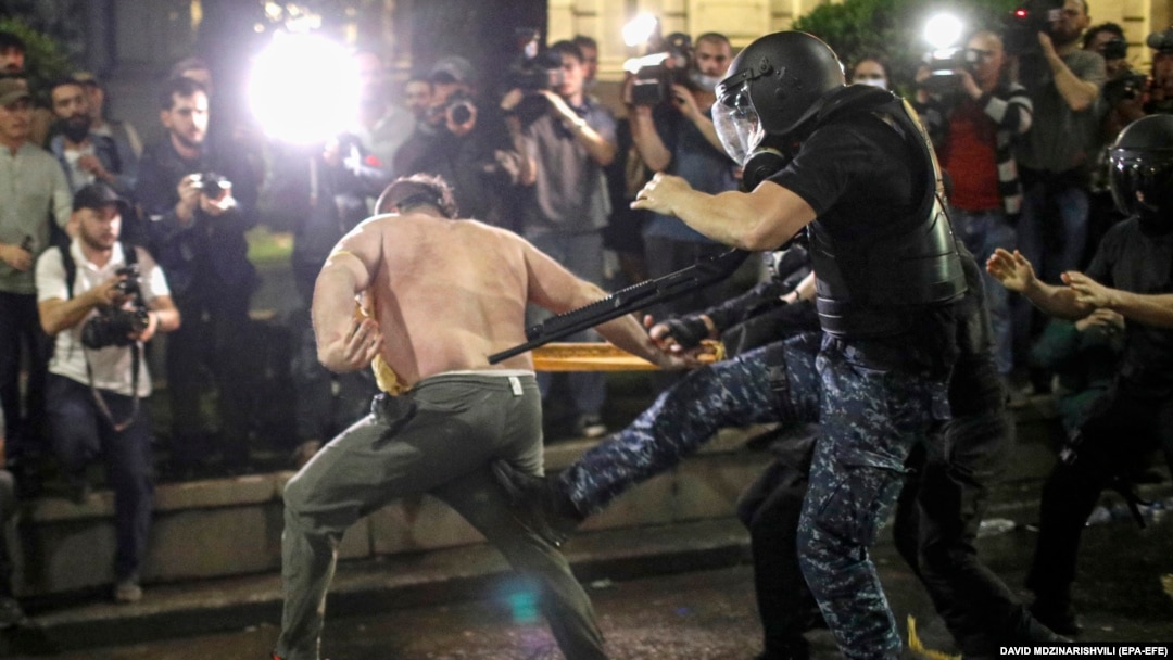 Riot police attack an opposition protester near the parliament building in Tbilisi on May 1. 