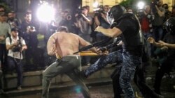 Riot police attack an opposition protester near the parliament building in Tbilisi on May 1. 