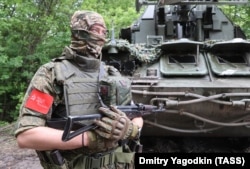 A Russian soldier, photographed in Ukraine's Donetsk region in July 2023, wears the Soviet victory banner, a flag that was raised over Germany's Reichstag by Red Army troops in May 1945.