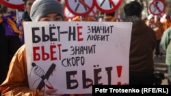 Әйелге зорлық-зомбылық жасауға қарсылық акциясында тұрған адам (Азаттық архивіндегі фото)