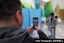 Сайлаушының дауыс беріп жатқан сәтін смартфонға түсіріп тұрған адам. Алматы, 19 наурыз, 2023 жыл.