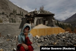 Дилшад Бано (51) седи на земја во близина на нејзината куќа, која беше оштетена по инцидент на излевање на глацијално езеро во Хасанабад.