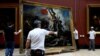 Служители инсталират картината „Свободата води народа, 1830“ от Йожен Дьолакроа (1798-1863) след шест месеца реставрация в музея Лувър в Париж, Франция, 30 април 2024 г.