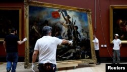 Служители инсталират картината „Свободата води народа, 1830“ от Йожен Дьолакроа (1798-1863) след шест месеца реставрация в музея Лувър в Париж, Франция, 30 април 2024 г.