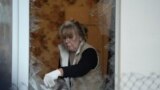 Женщина убирает осколки после очередного обстрела Киева 30 мая