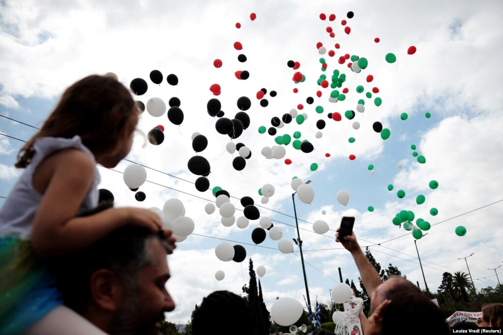 Protestuesit shikojnë balonat me ngjyrat e flamurit palestinez gjatë një marshi për Ditën Ndërkombëtare të Punëtorëve, në Athinë, Greqi.