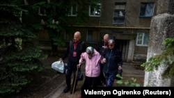 Волонтери допомагають місцевим жителькам під час їхньої евакуації з міста Торецьк, Донецька область, Україна, 8 травня 2024 року