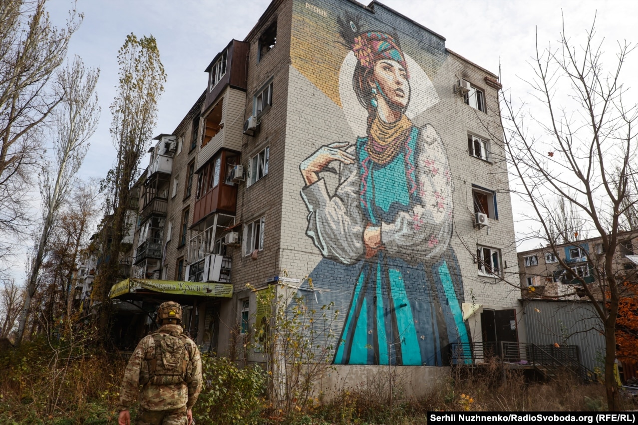 Một người lính đi bộ dưới bức tranh tường ở thị trấn Avdiyivka đang giao tranh ở Vùng Donetsk vào tháng 11 năm 2023.