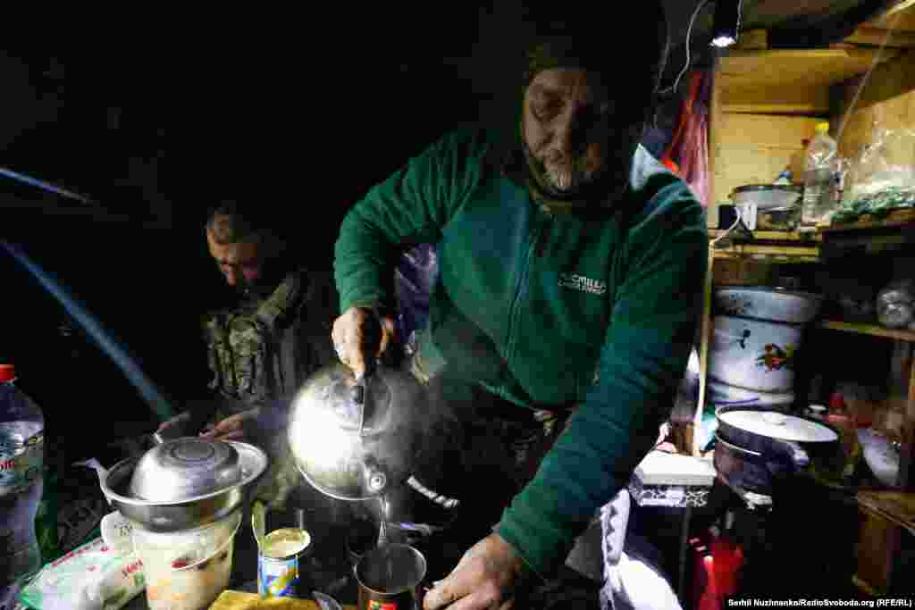 Një ushtar ukrainas me nofkën &quot;Lypa&quot; mbush me ujë të ngrohtë një tas. Për këta ushtarë, konflikti ka shkuar në mbajtjen e pozicioneve të tyre pasi moti i lagësht dimëror ka filluar të mbërrijë. &quot;Zoti është në anën tonë. Ne nuk e pushtuam (Rusinë)&quot;, tha Lypa. &nbsp;