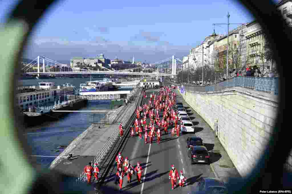 A group of people wearing Santa Claus costumes participate in the 8th Santa Claus Run in downtown Budapest.