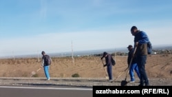 Işçiler Aşgabadyň daşyndaky gara ýoly bejerýär. (arhiw suraty) 
