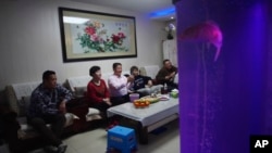 Kineska porodica gleda televiziju, Peking, 4. februara 2022.