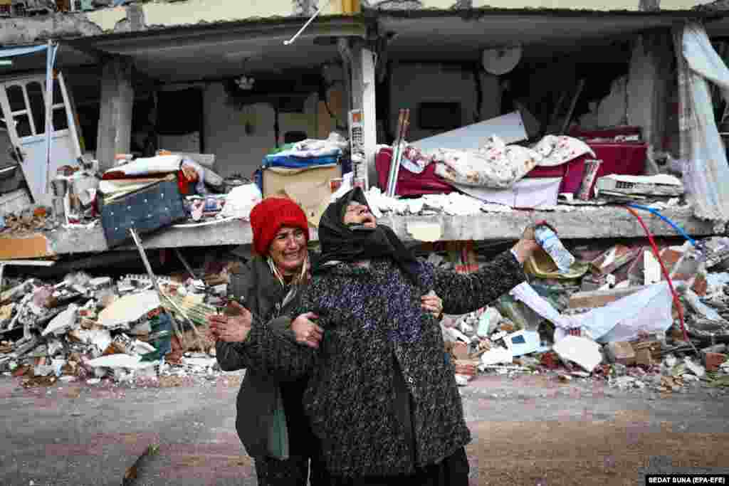 Женщины на месте обрушившегося здания после сильного землетрясения в Эльбистанском районе Кахраманмарас. Турция, 8 февраля 2023 года. Более 9000 человек погибли и еще тысячи получили ранения после двух сильных землетрясений, произошедших на юге Турции и на севере Сирии. 6 февраля. (EPA-EFE/SEDAT SUNA)