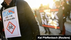 Manifestant purtând o pancartă pe care scrie „AfD otravă pentru democrație", în timp unei demonstrații împotriva celebrării celei de-a 10-a aniversări a AfD în Koenigstein, Germania, 6 februarie 2023