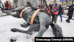 Workers dismantle the monument to Mykola Shchors in the center of Kyiv on December 9.