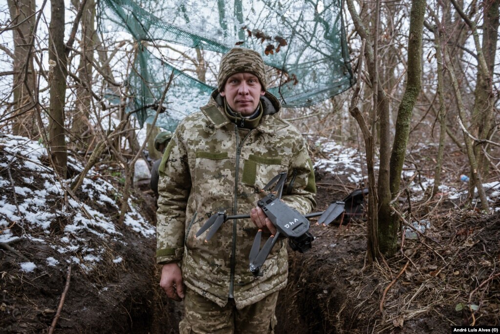 Një ushtar ukrainas duke e mbajtur në dorë një dron.