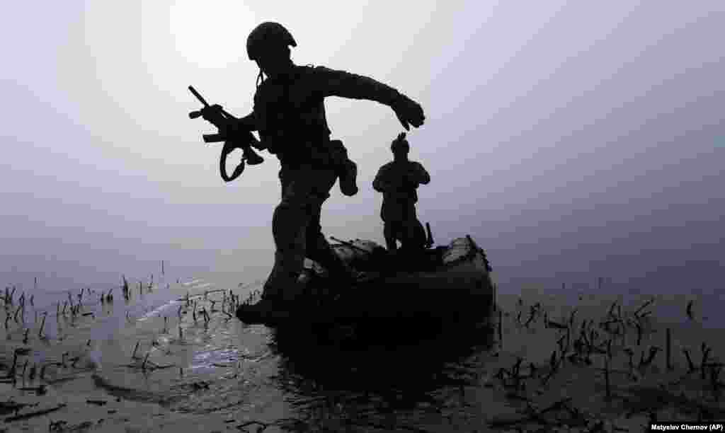 Украінскі вайсковец выскоквае з лодкі на беразе Дняпра на лініі фронту пад Херсонам. Украіна. 15 кастрычніка 2023&nbsp;