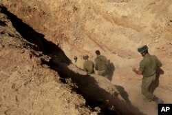 Soldații israelieni intră într-un tunel descoperit în apropierea graniței dintre Israel și Fâșia Gaza, 13 octombrie 2013.