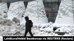 Čovek hoda u Helsinkiju pod snegom i ledom, 3. januar 2024.