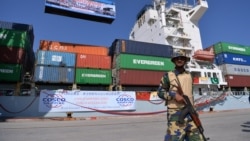 A Pakistani soldier stands guard beside a ship carrying containers during the opening of a trade project in Gwadar Port in 2016. 