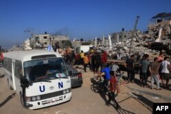 Autobus UN-a prolazi pored uništene zgrade nakon izraelskog bombardovanja Rafe na jugu Pojasa Gaze, 10. novembra