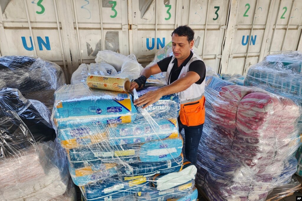 Punëtorët e ndihamve të Kombeve të Bashkuara dhe të Gjysmëhënës së Kuqe përgatisin pakot për t'i shpërndarë te palestinezët, nga një magazinë e UNRWA-së në Deir Al-Balah, Rripi i Gazës.