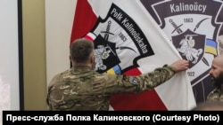 Белорусские добровольцы "Дядька" и "Ден" полка имени Кастуся Калиновского, сражающегося на стороне Украины, расправляют флаг формирования. Киев, 29 ноября 2023 года