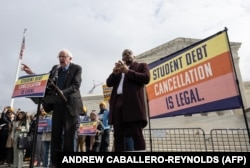 Сенатор Берни Сандерс (слева) выступает на демонстрации у здания Верховного суда США в защиту прощения студенческих долгов