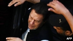 د پاکستان رېنجرز ځواک سرتېري د مې پر نهمه عمران خان ګاډي کې کښېنوي.