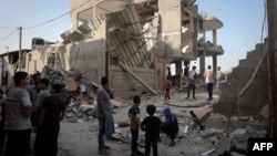 Civilët palestinezë në Rafah shikojnë dëmet e shkaktuara nga një sulm izraelit ndaj një ndërtese në këtë qytet në jug të Gazës. 3 maj 2024. 
