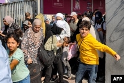 Беженцы проходят через ворота на пограничном переходе Рафах между Египтом и сектором Газа. 1 ноября 2023 года