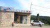 Nagorno-Karabakh - An abandoned vehicle is parked in front of a closed shop in Stepanakert during an Azeri government organized media trip, October 2, 2023. 