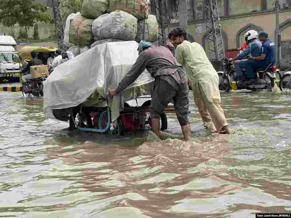 Men try to ferry their goods across the floodwaters. &nbsp;