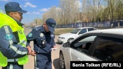 Полицейские останавливают активиста Марата Жыланбаева и просят его проехать в участок, заявляя о нарушении правил дорожного движения. 1 мая 2023 года