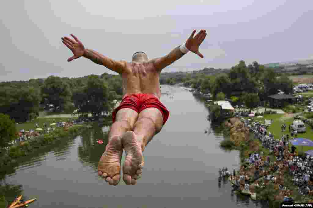 A competitor jumps from a 22-meter-high bridge during an annual high-diving competition near the town of Gjakova in Kosovo.&nbsp;