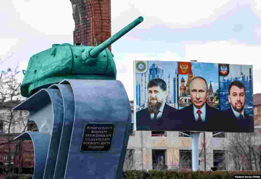A billboard featuring Chechen ruler Ramzan Kadyrov (left), Russian President Vladimir Putin (center), and Denis Pushilin, the administrator of Russian-controlled parts of the Donetsk region, in front of a memorial in Mariupol on February 16, 2023. The UN report estimates that some 350,000 people were forced to leave the city from a total population of approximately 450,000 before the war.