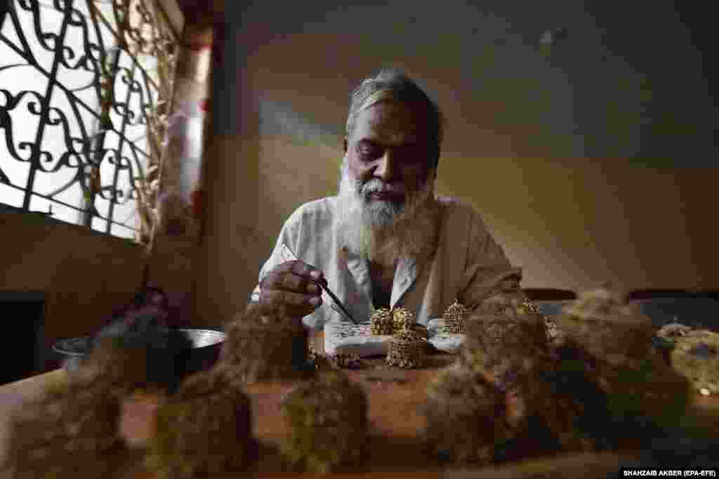 A goldsmith crafts gold jewelry at a workshop in Karachi, Pakistan, where gold prices rose despite a decline in international rates.