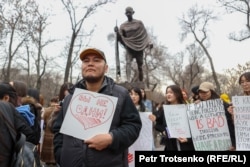 Әйел құқығын қорғауға арналған митингіде "Жалғыз емессіздер!" деген жазу ұстап тұрған ер адам. Алматы, 8 наурыз, 2023 жыл.