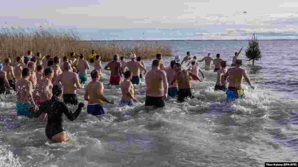Ljudi ulaze u hladnu vodu mađarskog jezera Balaton tokom tradicionalnog novogodišnjeg kupanja.