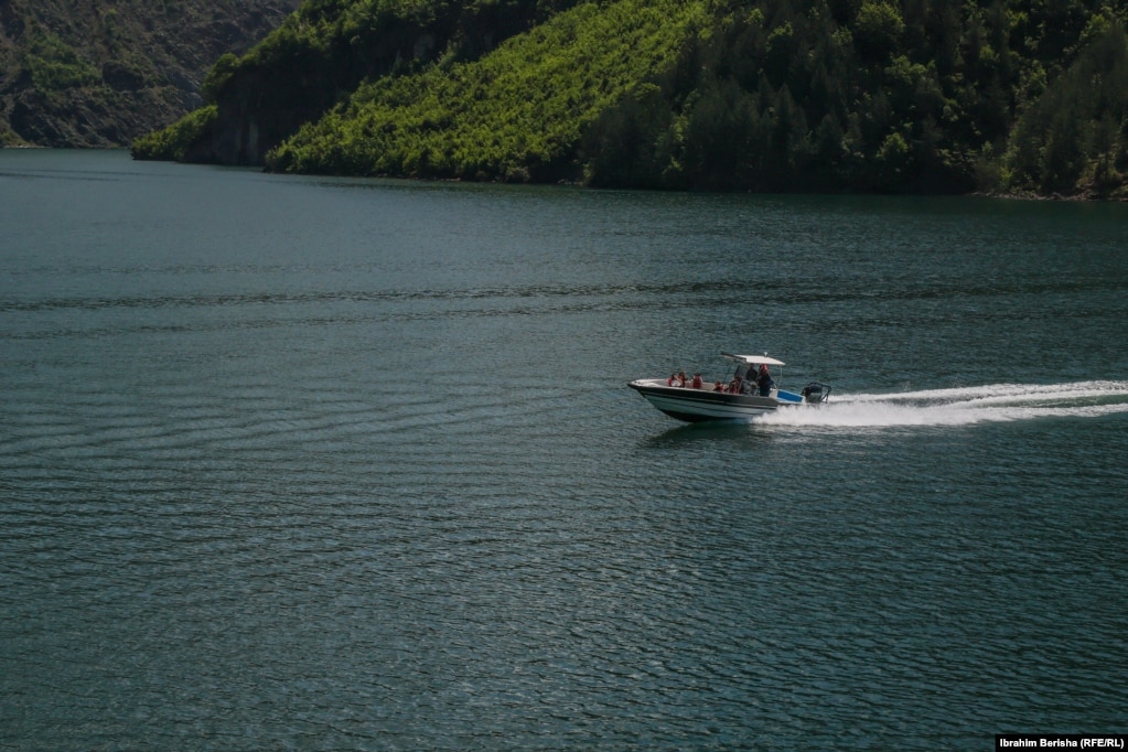 Një varkë me turistë në ujërat e liqenit.