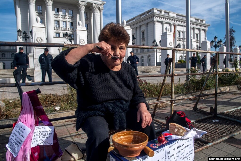 Një pensioniste duke ngrënë një shujtë gjatë një proteste ku u kërkua rritja e pensioneve dhe përmirësimi i kushteve të jetesës, para ndërtesës së Qeverisë në Shkup, Maqedoni e Veriut.