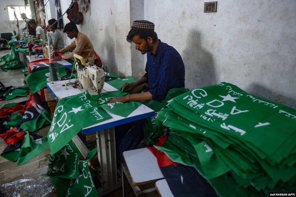 Punëtorët në një fabrikë në Karaçi duke qepur flamujt e Aleancës së Madhe Demokratike (GDA) -- një yll i bardhë -- dhe të Partisë Popullore të Pakistanit (PPP) -- një shpatë. Tashmë janë pranuar dokumentet e nominimit për rreth 23.000 kandidatë që garojnë për asamble kombëtare dhe lokale.