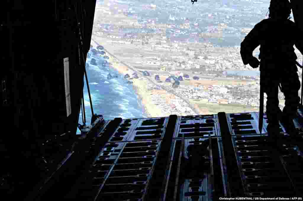 Vojnik pored tereta američkog ratnog zrakoplovstva pušta palete humanitarne pomoći s hranom i vodom iznad Gaze, 2. marta 2024.