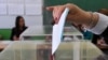 Serbia - A Serbian voter casts her ballot at a polling station in Belgrade on March 16, 2014