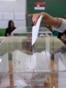 Serbia - A Serbian voter casts her ballot at a polling station in Belgrade on March 16, 2014