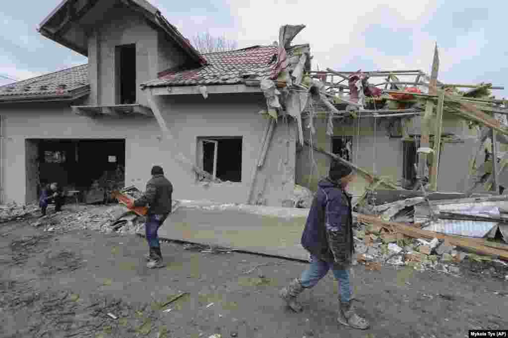 Villagers clear the rubble from a destroyed home in the village in Zolochevskiy.&nbsp;&nbsp;