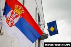 Flamuri i Serbisë (majtas) shihet në një shtyllë elektrike, teksa flamuri i Kosovës qëndronte në një ballkon të ndërtesës komunale në Zubin Potok, në veri të Kosovës, më 31 maj 2023. (Foto: AP)