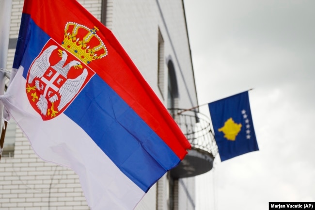 Flamuri i Serbisë (majtas) shihet në një shtyllë elektrike, teksa flamuri i Kosovës qëndronte në një ballkon të ndërtesës komunale në Zubin Potok, në veri të Kosovës, më 31 maj 2023. (Foto: AP)